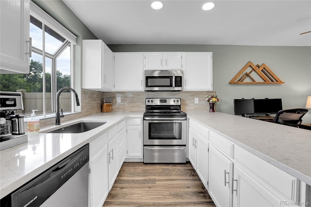 9615 W Chatfield Ave Unit C, Littleton, CO 80128 - kitchen featuring appliances with stainless steel finishes, recessed lighting, backsplash, white cabinetry, and wood finished floors