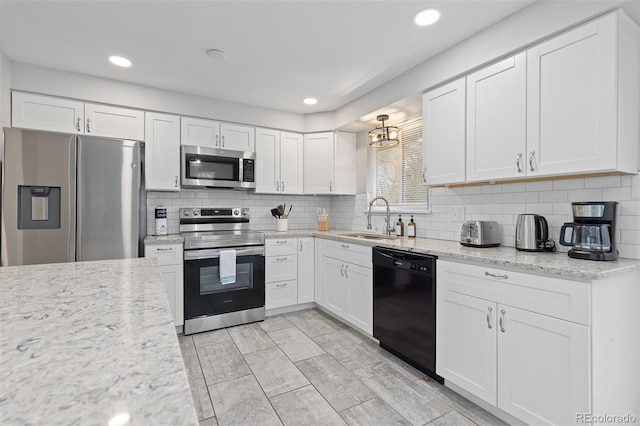 8506 Eaton St, Arvada, CO 80003 - kitchen with stainless steel appliances, a sink, white cabinetry, tasteful backsplash, and light stone counters