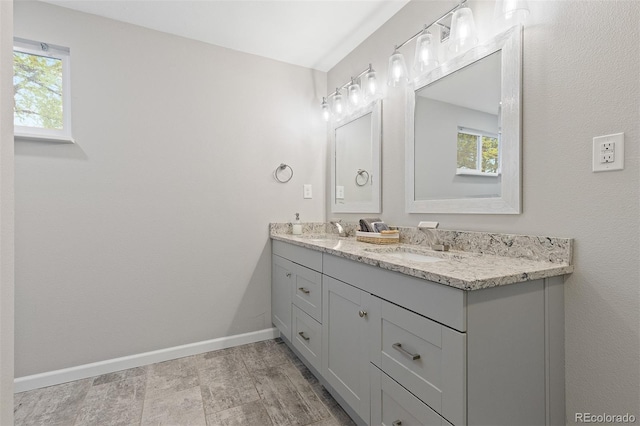 8506 Eaton St, Arvada, CO 80003 - full bath with double vanity, healthy amount of natural light, and baseboards