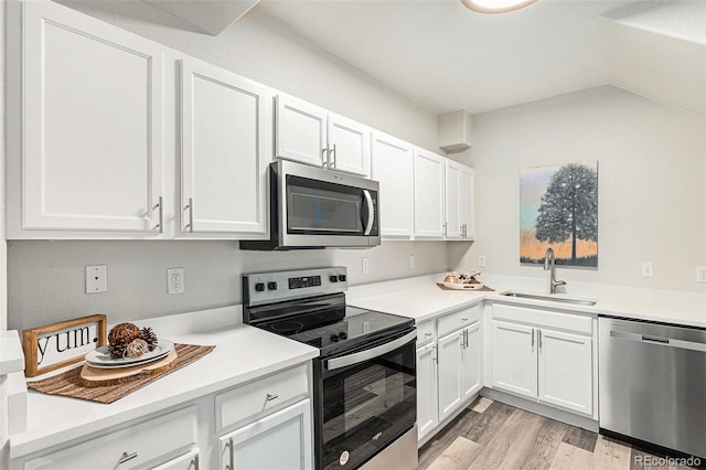 kitchen featuring sink, white cabinets, light hardwood / wood-style floors, and appliances with stainless steel finishes