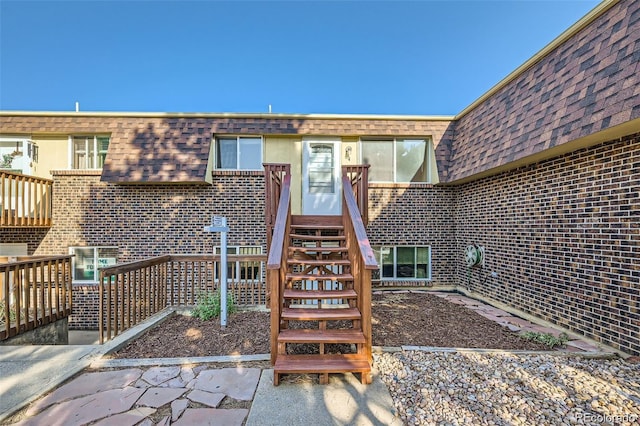 2241 Dexter Dr Unit 3, Longmont, CO 80501 - view of exterior entry with mansard roof, brick siding, and a shingled roof