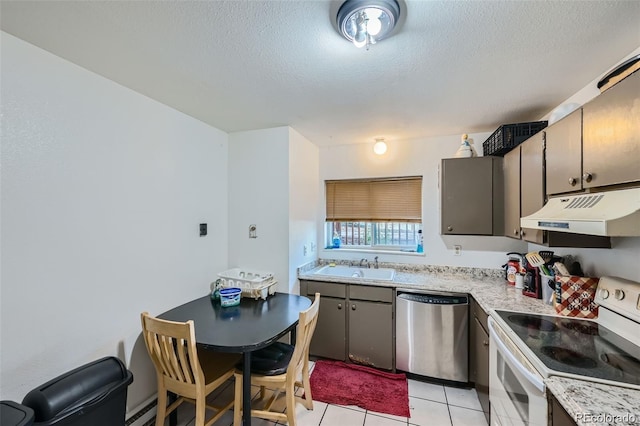 2241 Dexter Dr Unit 3, Longmont, CO 80501 - kitchen with white electric stove, dishwasher, under cabinet range hood, light countertops, and light tile patterned floors