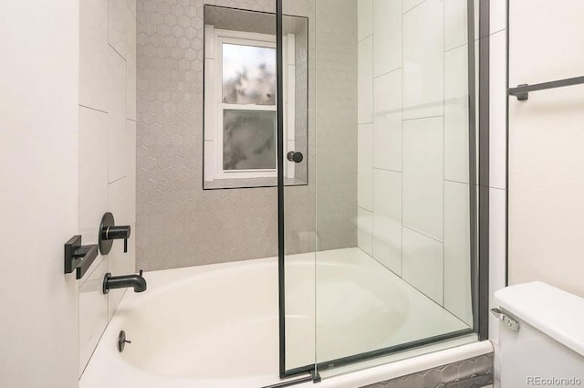 bathroom with shower / bath combination with glass door and toilet