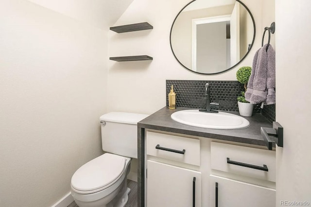 bathroom with wood-type flooring, vanity, toilet, and decorative backsplash