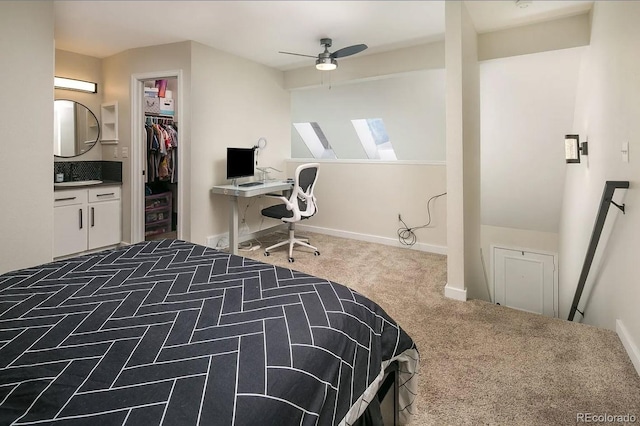 carpeted bedroom with a closet, a walk in closet, ceiling fan, and ensuite bathroom