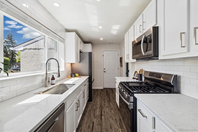 4500 Zephyr St, Wheat Ridge, CO 80033 - kitchen featuring appliances with stainless steel finishes, a sink, white cabinetry, and recessed lighting