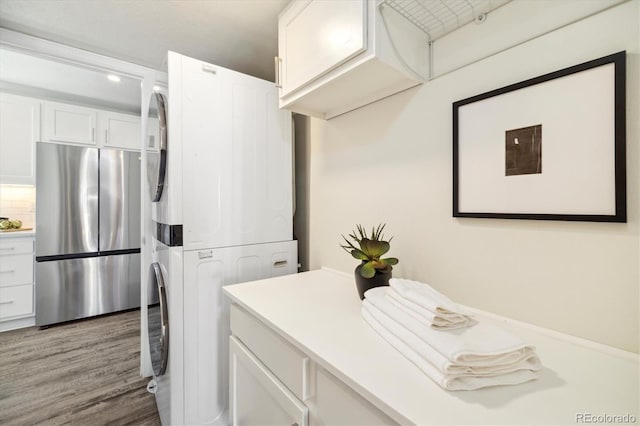4500 Zephyr St, Wheat Ridge, CO 80033 - laundry area featuring stacked washer and clothes dryer and wood finished floors