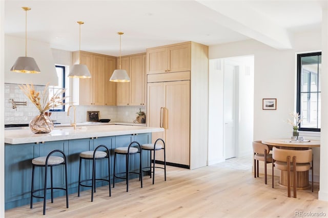 1680 S Humboldt St, Denver, CO 80210 - kitchen with paneled built in fridge, light brown cabinetry, tasteful backsplash, light wood-style floors, and light countertops