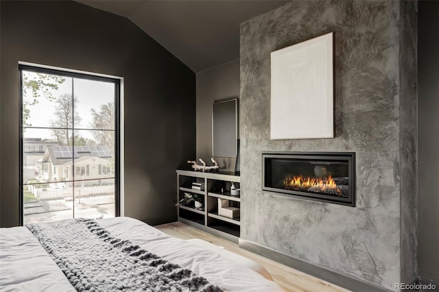 1680 S Humboldt St, Denver, CO 80210 - bedroom with wood finished floors, a glass covered fireplace, and vaulted ceiling