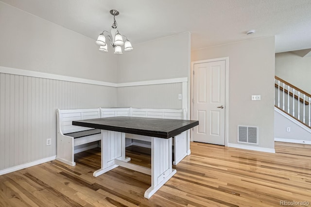 unfurnished dining area with light hardwood / wood-style floors and an inviting chandelier