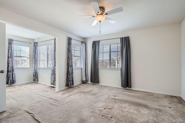 carpeted empty room featuring ceiling fan and a textured ceiling