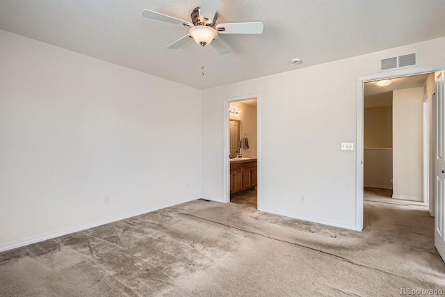 unfurnished bedroom featuring carpet flooring, ensuite bathroom, and ceiling fan