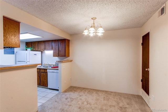 kitchen with pendant lighting, white appliances, light carpet, and a chandelier