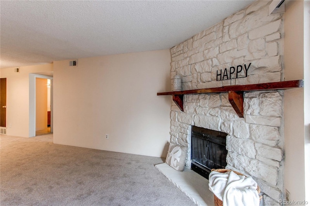 unfurnished living room with a stone fireplace, carpet floors, and a textured ceiling