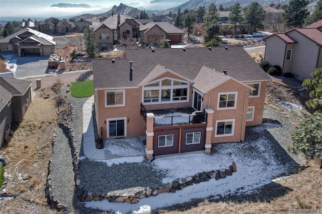 exterior space with a patio, a residential view, a mountain view, and stucco siding