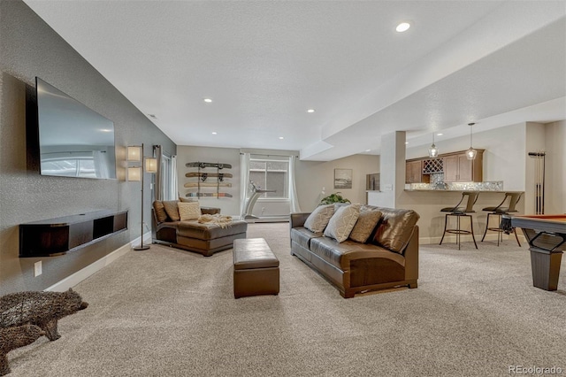 living area with recessed lighting, light colored carpet, indoor bar, and baseboards