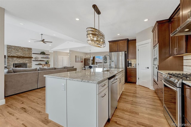 kitchen featuring light wood-style flooring, appliances with stainless steel finishes, and backsplash