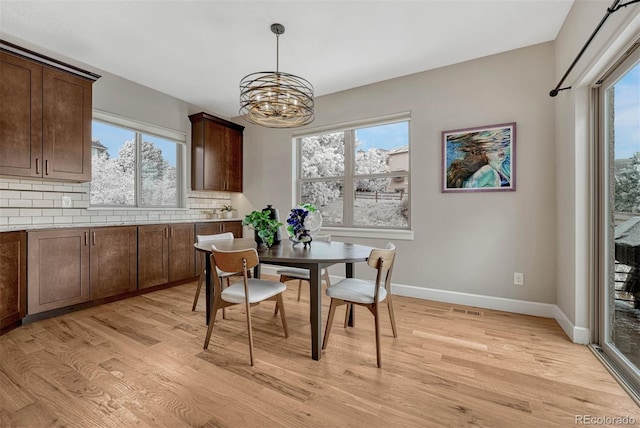 dining space featuring a wealth of natural light, light wood-style flooring, and baseboards