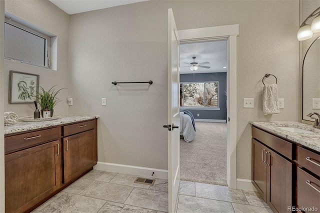 ensuite bathroom with visible vents, connected bathroom, vanity, and baseboards