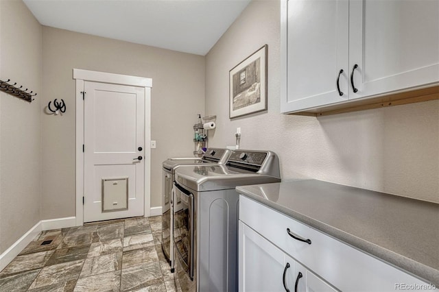 laundry room featuring baseboards, cabinet space, and washer and dryer