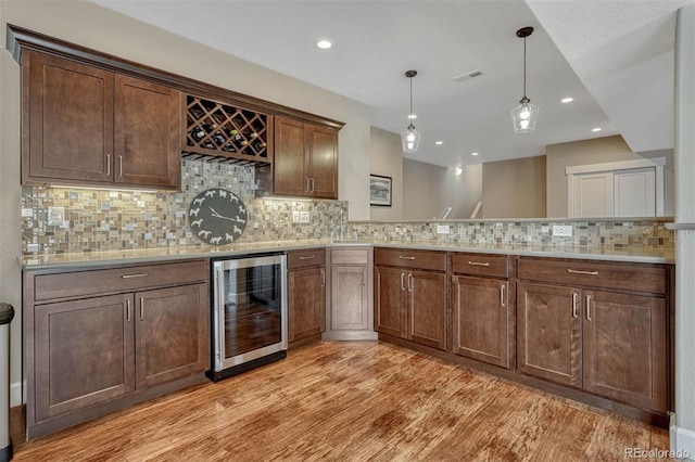 kitchen featuring light countertops, beverage cooler, visible vents, and light wood-style flooring