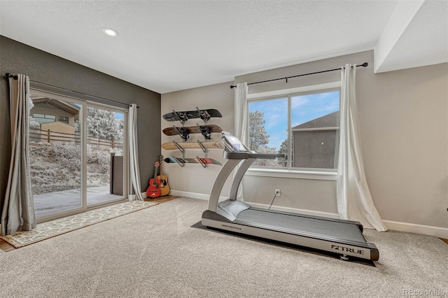 exercise area with a textured ceiling, baseboards, and a wealth of natural light