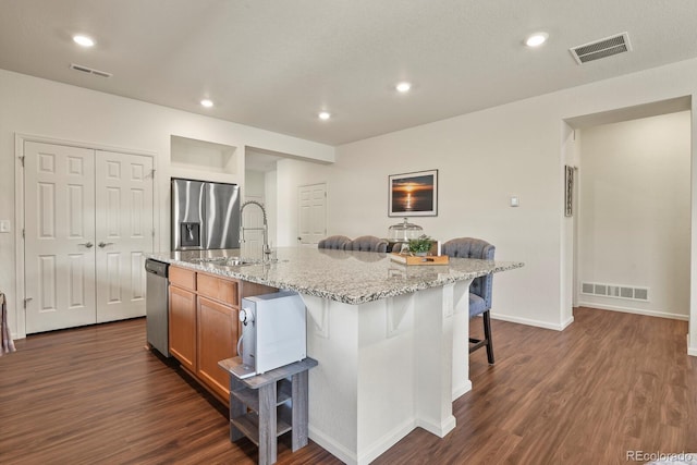 kitchen with visible vents, dark wood-style floors, stainless steel appliances, and a sink