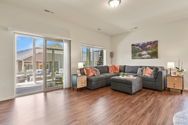living area with visible vents, baseboards, and wood finished floors