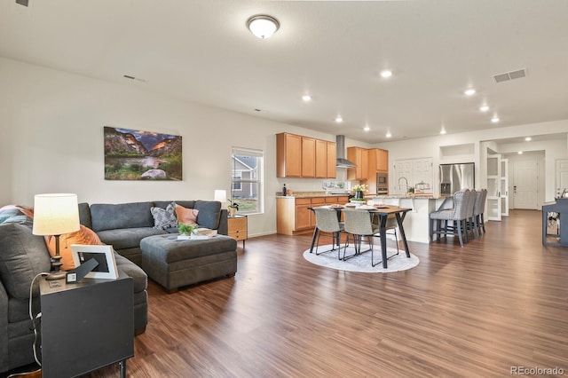 living room with dark wood-type flooring, visible vents, and recessed lighting