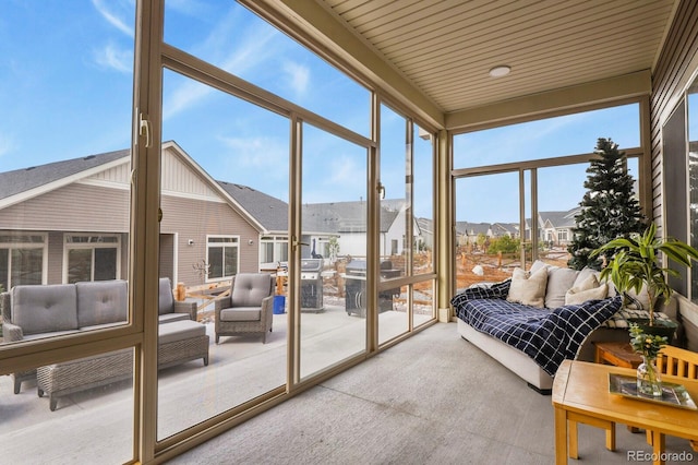 sunroom / solarium featuring a residential view, floor to ceiling windows, carpet, and an outdoor living space