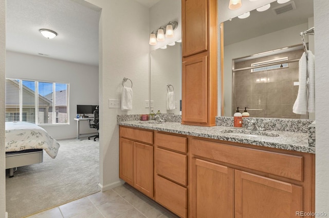 full bathroom with a shower stall, tile patterned flooring, double vanity, visible vents, and a sink