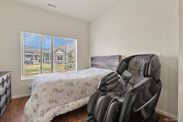 bedroom featuring visible vents, wood finished floors, baseboards, and multiple windows