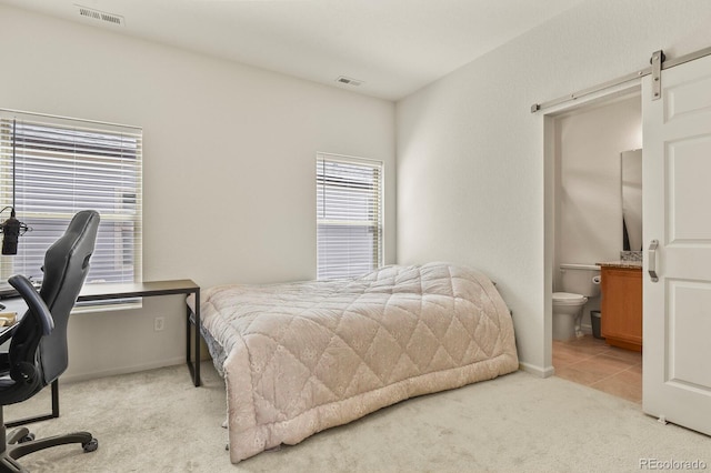 bedroom featuring ensuite bath, baseboards, visible vents, and light colored carpet