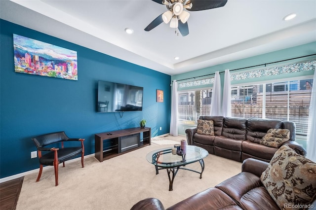 carpeted living room with ceiling fan