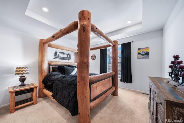 carpeted bedroom with a raised ceiling