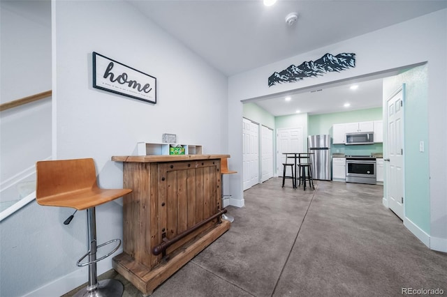 bar featuring white cabinetry and stainless steel appliances