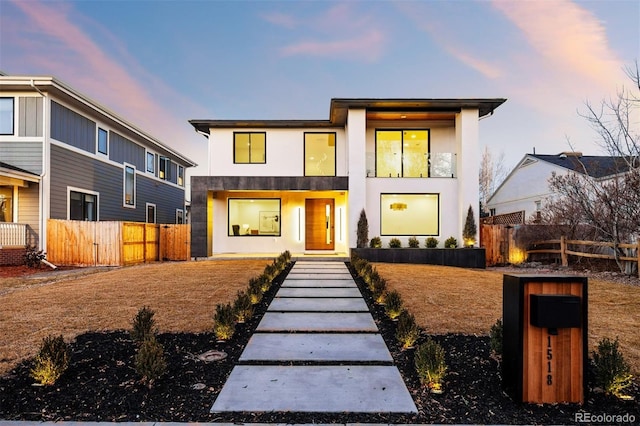 contemporary house with fence and stucco siding