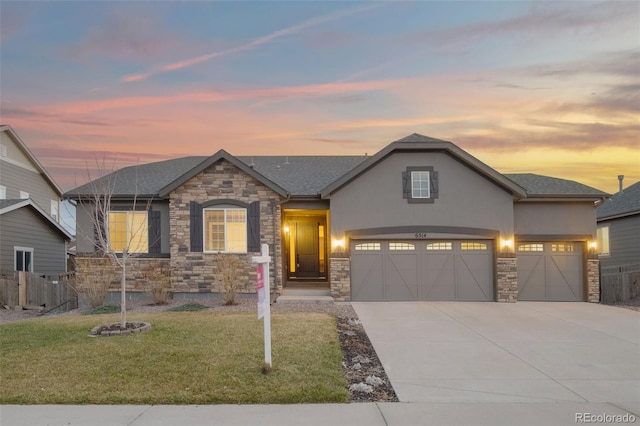 6514 Agave Ave, Castle Rock, CO 80108 - view of front of property featuring stone siding, a lawn, concrete driveway, fence, and stucco siding