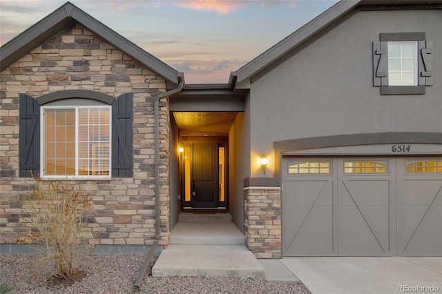 6514 Agave Ave, Castle Rock, CO 80108 - view of exterior entry with stone siding, a garage, and stucco siding