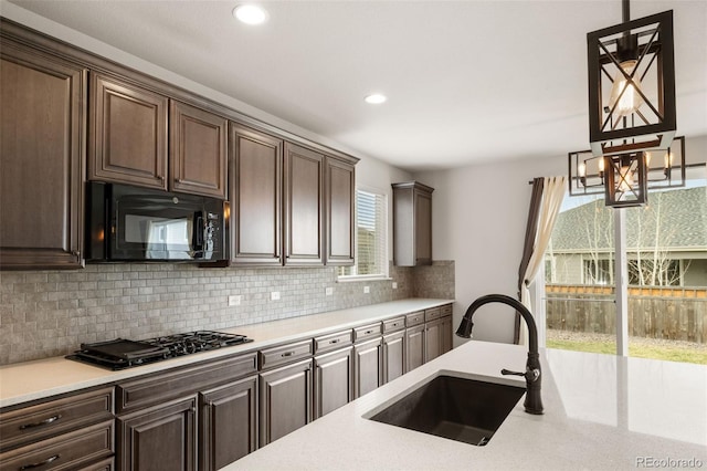 6514 Agave Ave, Castle Rock, CO 80108 - kitchen with light countertops, dark brown cabinets, black appliances, decorative backsplash, and a sink