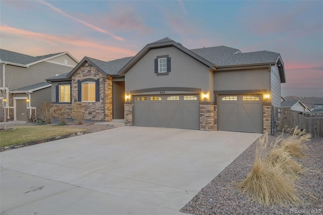 6514 Agave Ave, Castle Rock, CO 80108 - view of front of home featuring stucco siding, fence, stone siding, an attached garage, and concrete driveway