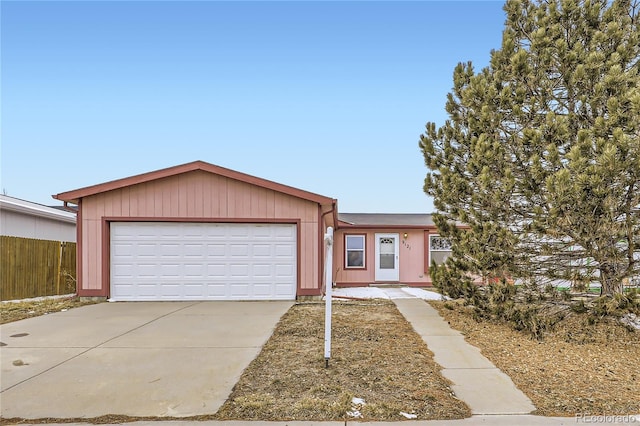 view of front of property with driveway, an attached garage, and fence