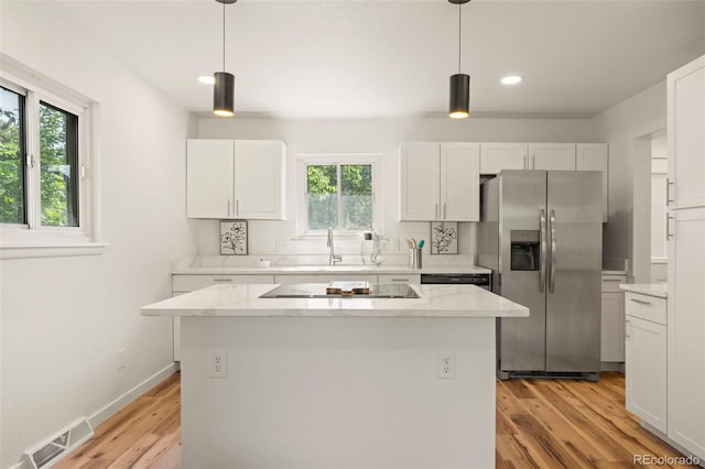 871 S Worchester St, Aurora, CO 80012 - kitchen with black appliances, plenty of natural light, white cabinets, recessed lighting, and a kitchen island