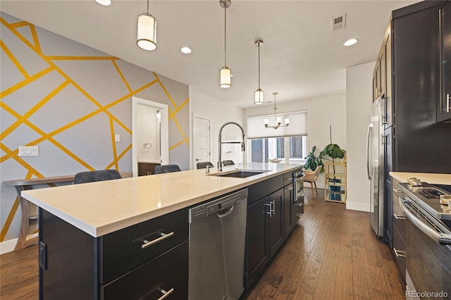 kitchen featuring light countertops, a sink, visible vents, a kitchen island with sink, and appliances with stainless steel finishes