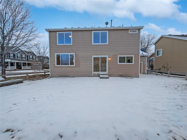 snow covered property with entry steps and fence