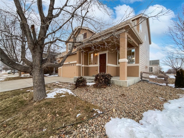 view of snowy exterior featuring a garage, concrete driveway, and stucco siding