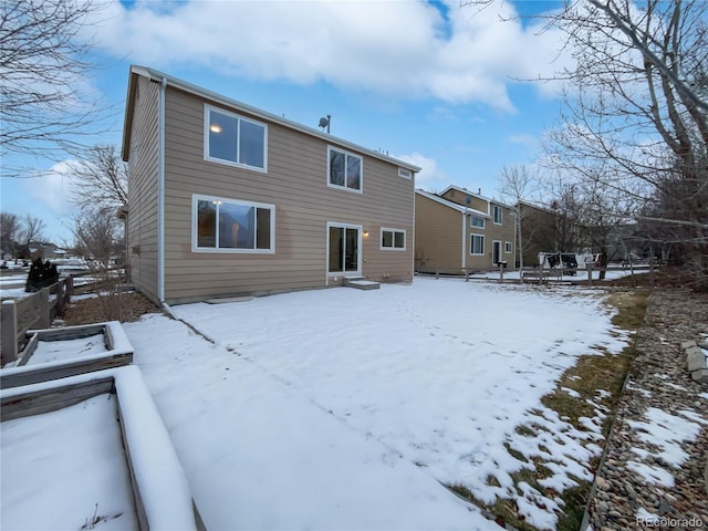 snow covered property with entry steps and fence