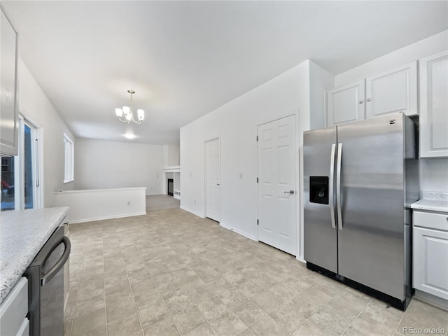 kitchen featuring hanging light fixtures, white cabinetry, stainless steel refrigerator with ice dispenser, and light countertops