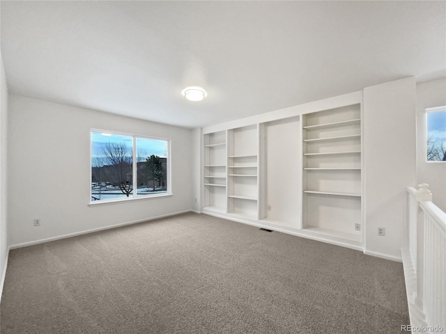 empty room featuring carpet and baseboards