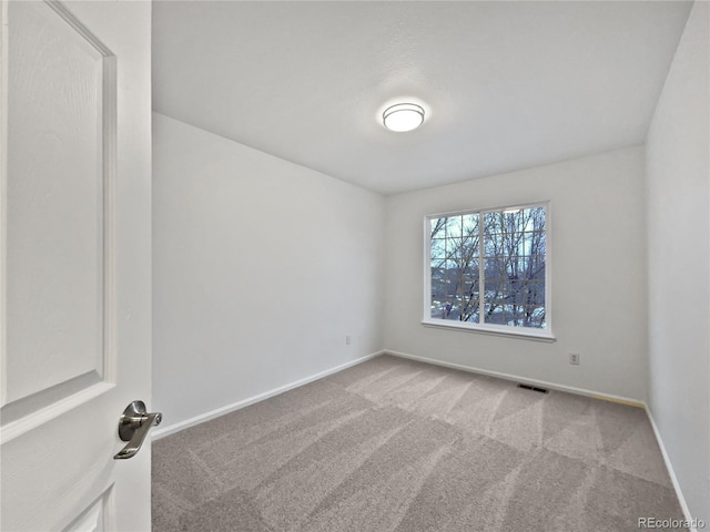 carpeted empty room with visible vents and baseboards